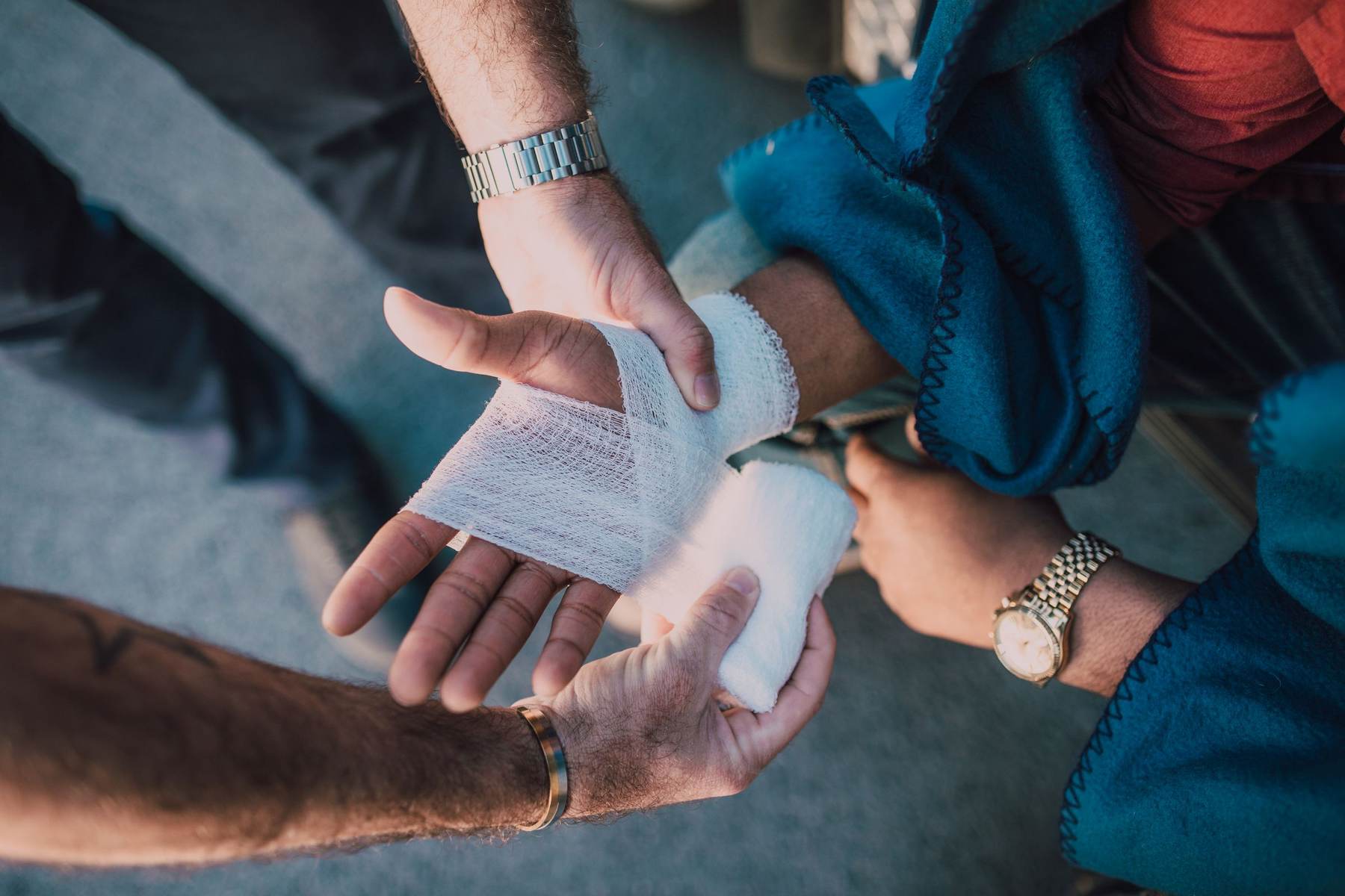 Two people bandaging an injured hand during first aid practice