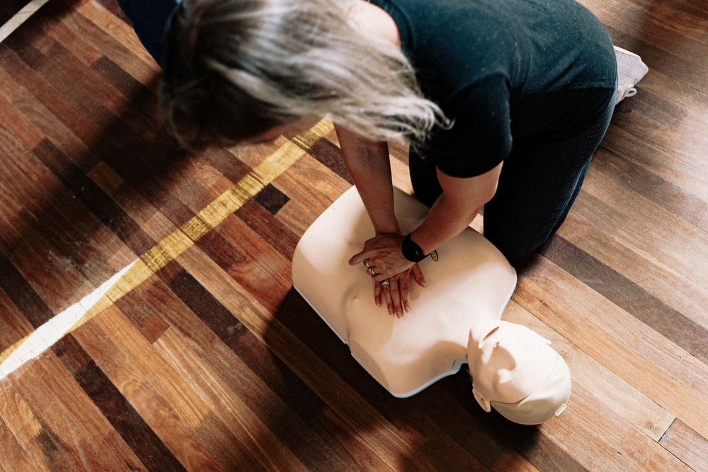 Learner practising chest compressions on a CPR training manikin